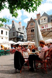 A student is sitting in the outdoor area of a café in the picturesque old town of Tours, France.